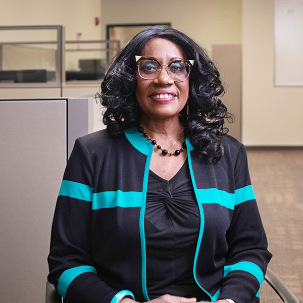 Woman in business clothes sits in office.