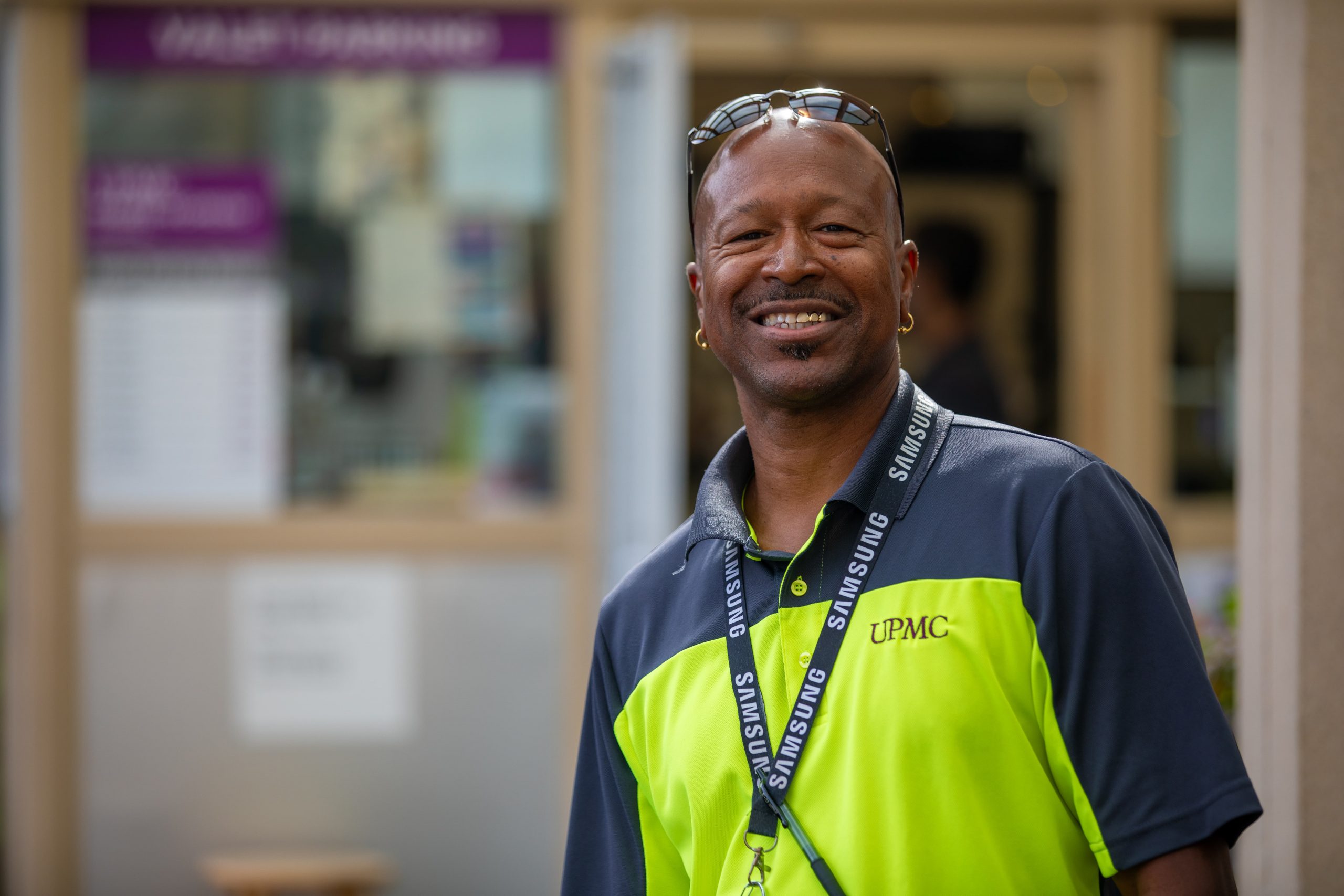 Man in sunglasses in parking lot with smile on face.