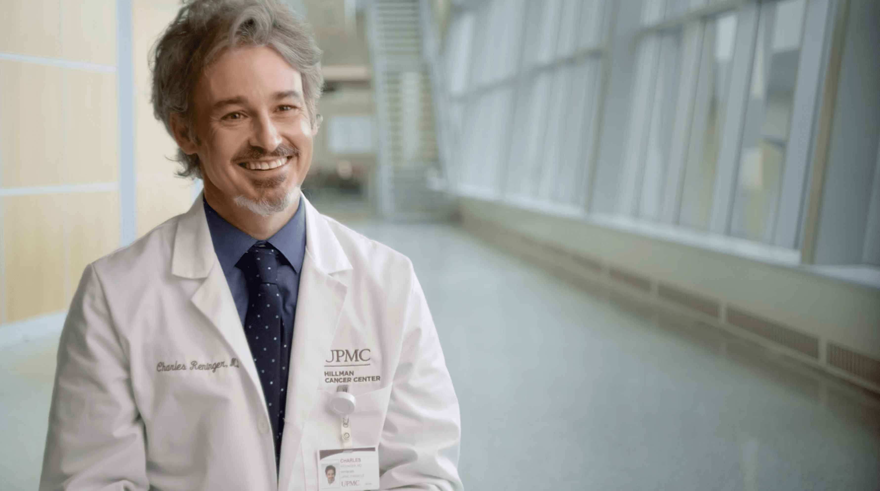 Bearded physician smiles.