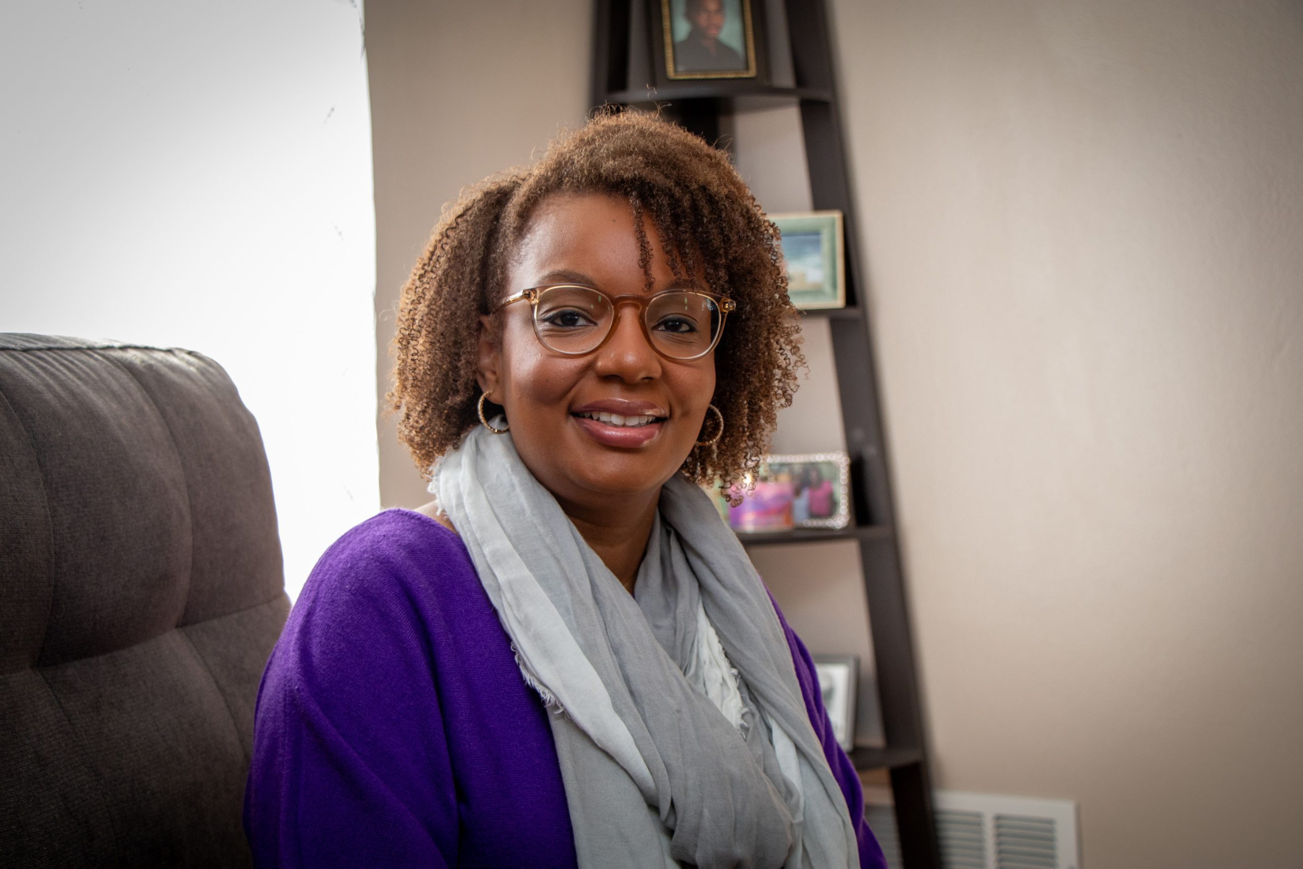 Home health nurse sitting in a chair in someone's living room.