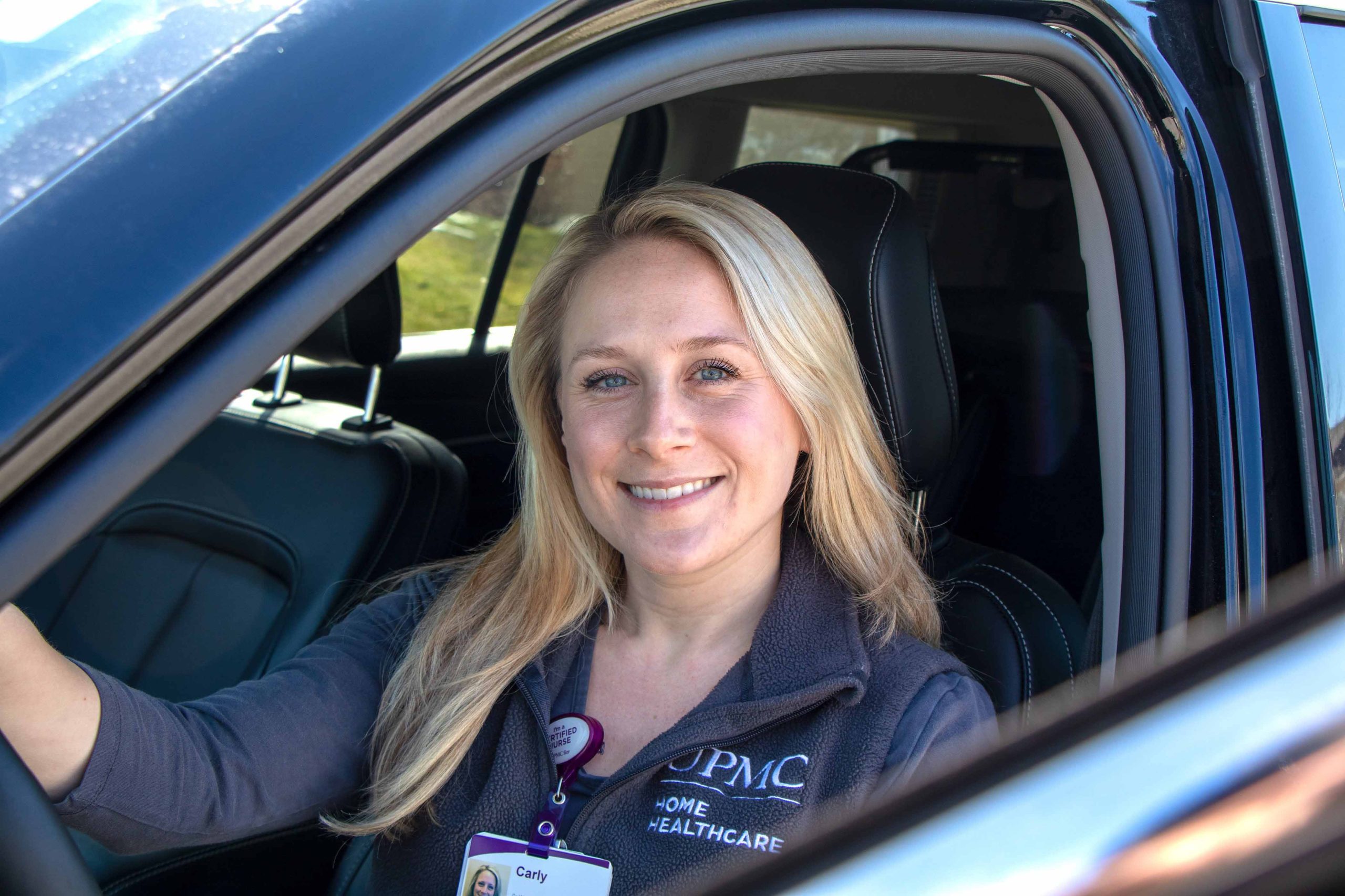 Home health nurse sitting in her car's driver's seat.