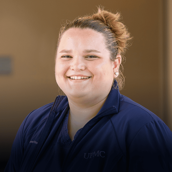 Young nurse smiling in hallway.
